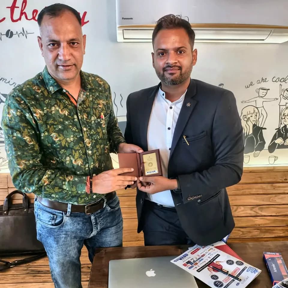 A ProperPaisa advisor handing a Tanishq gold coin to a customer after their loan was disbursed