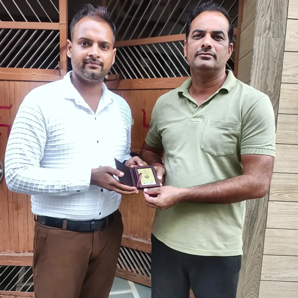 A ProperPaisa advisor handing a Tanishq gold coin to a customer after their loan was disbursed